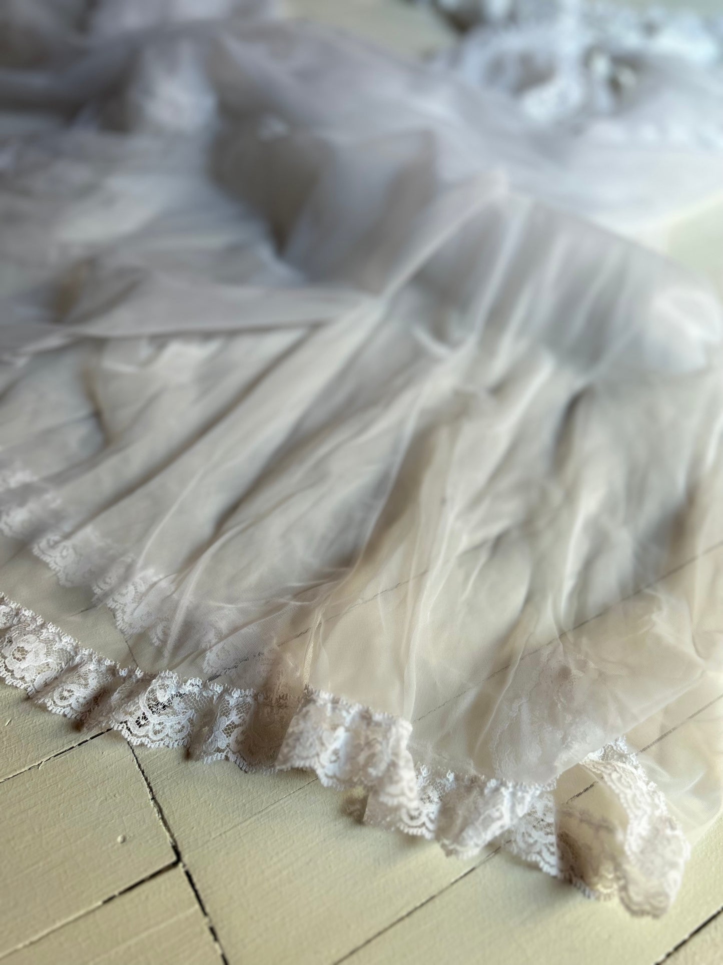 White sheer and lace lingerie on a light wooden floor