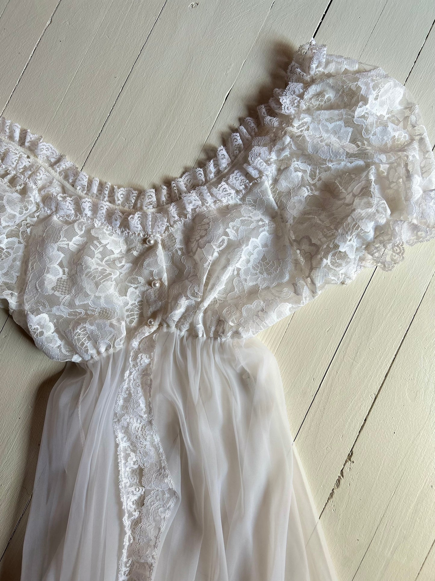 White sheer and lace lingerie on a light wooden floor