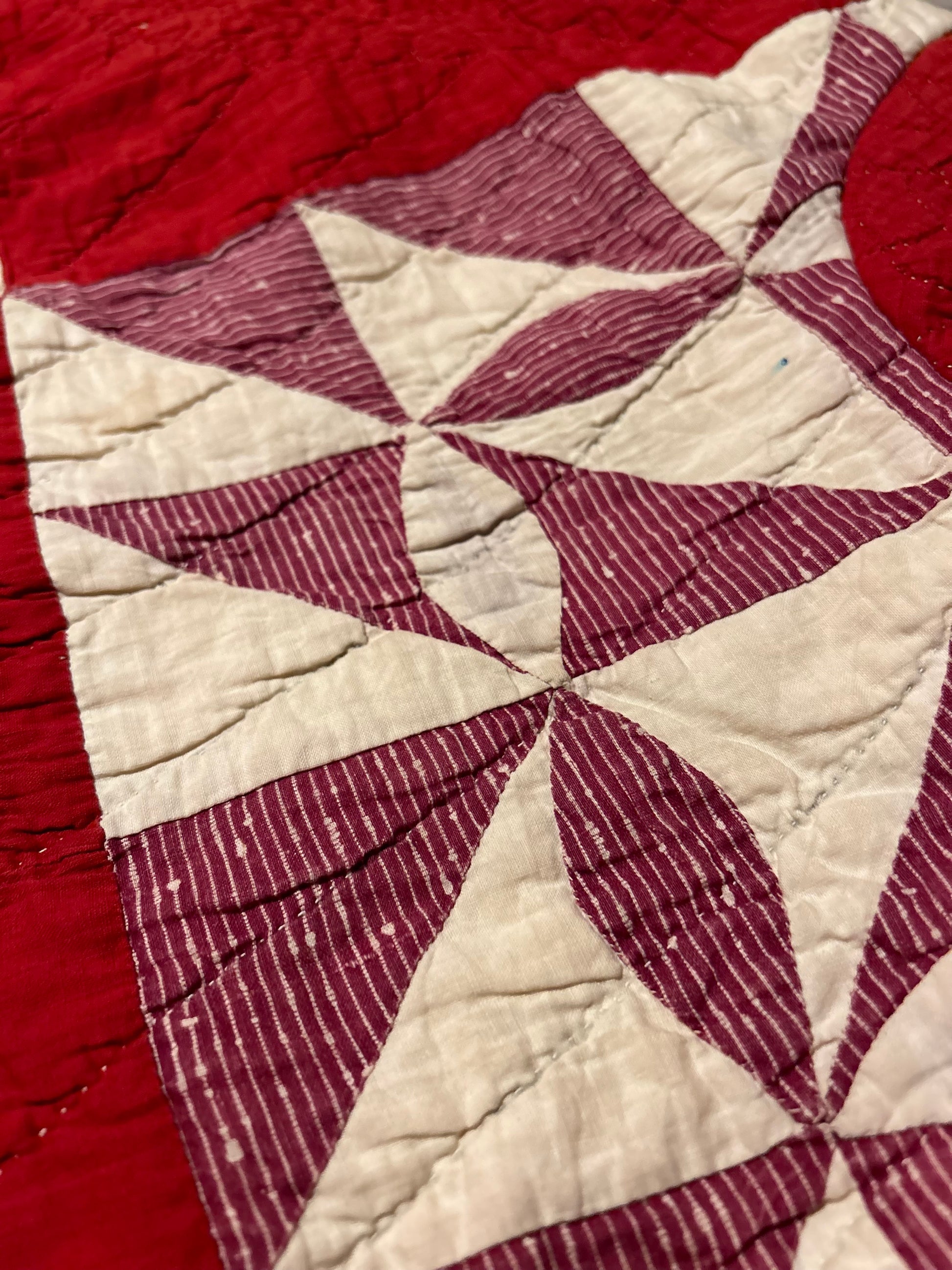 Close up of Vintage Quilted handmade jacket with red and white pattern highlighting natural characteristics and aging.
