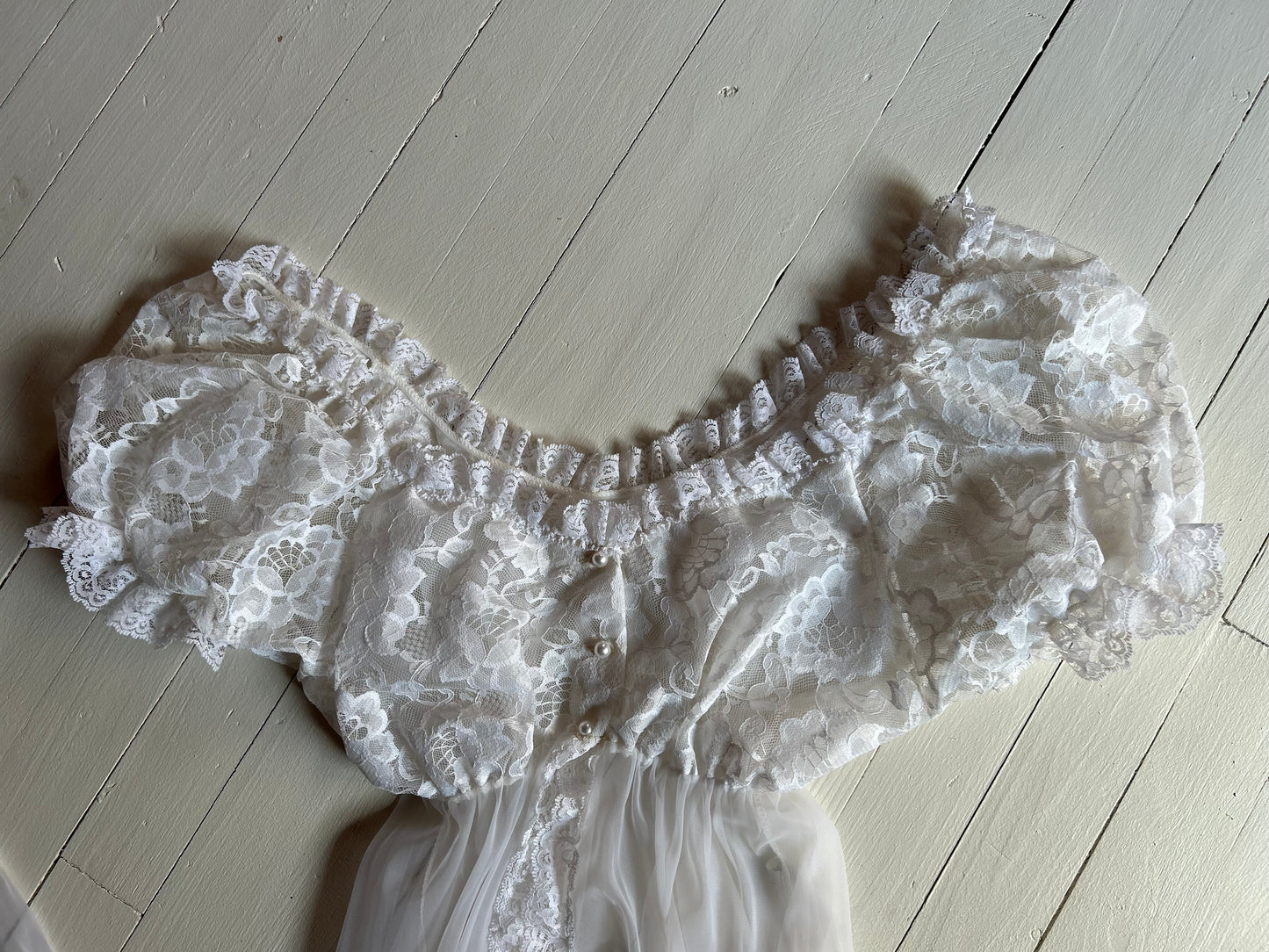 White sheer and lace lingerie on a light wooden floor