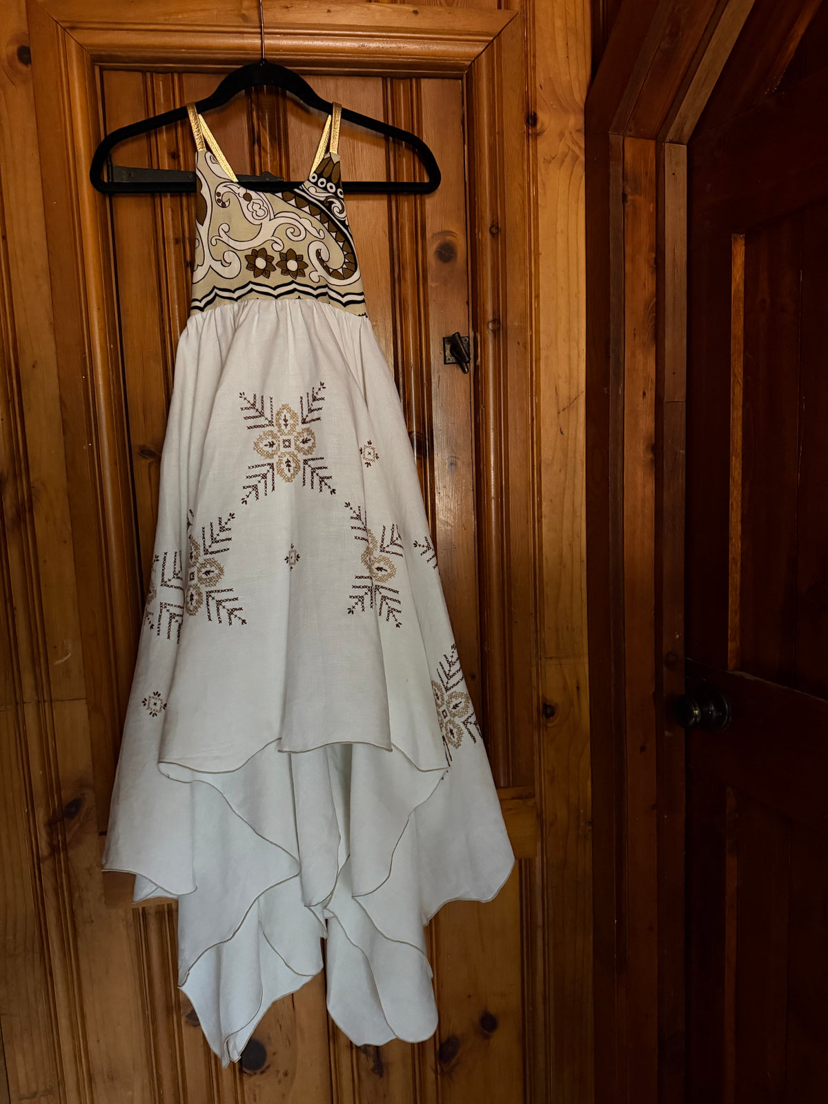 Dress with wood background and brown skirt embroidered snowflakes. Gold straps. Handkerchief hem. 