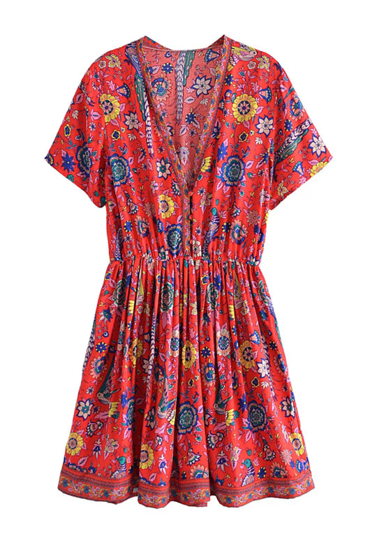 White background. The front of a  red floral print dress with birds and flowy skirt and an elastic cinch waist.