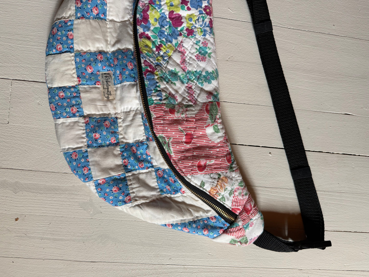 Floral-patterned bag with a strap on a wooden floor