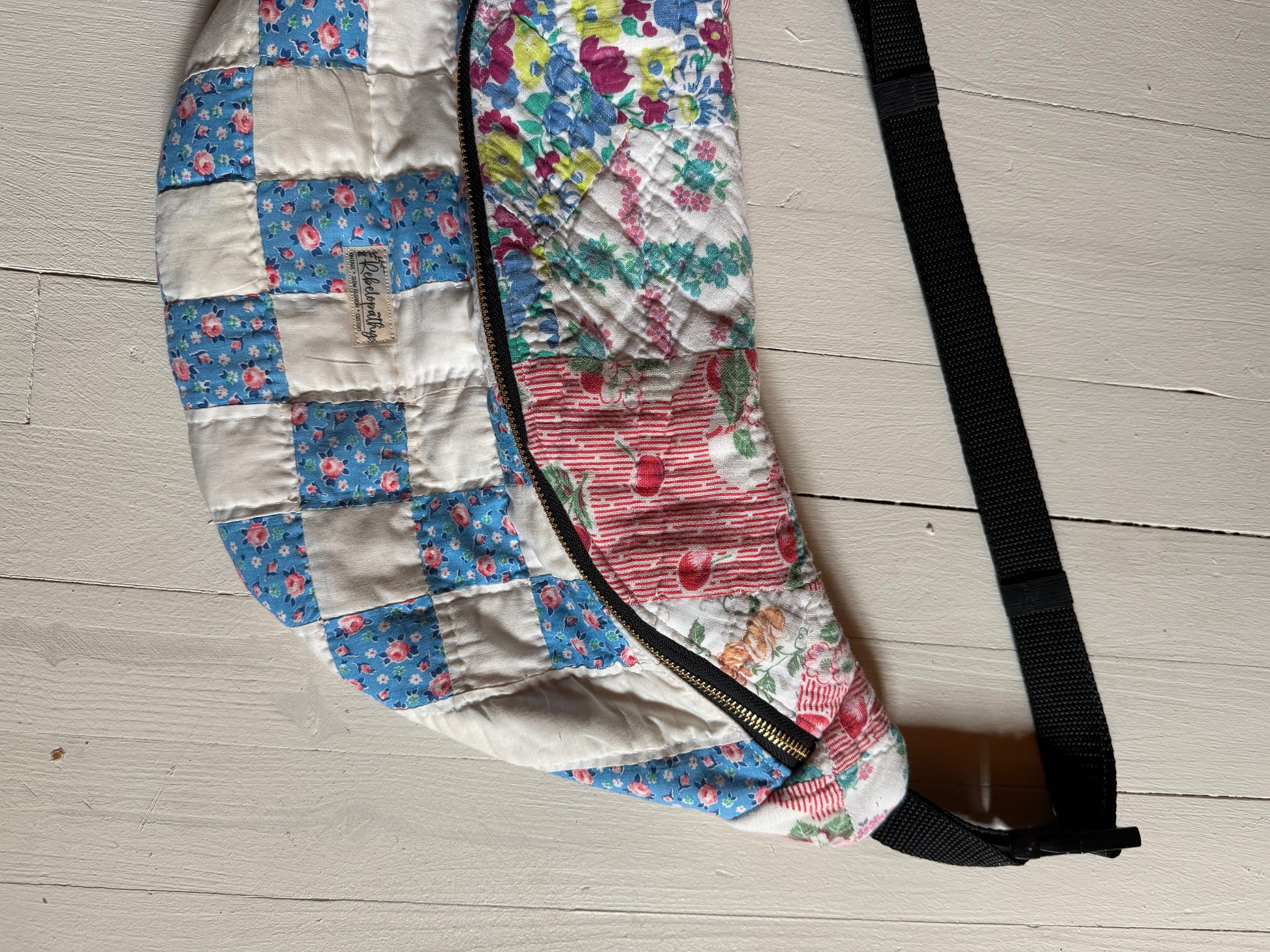 Floral-patterned bag with a strap on a wooden floor