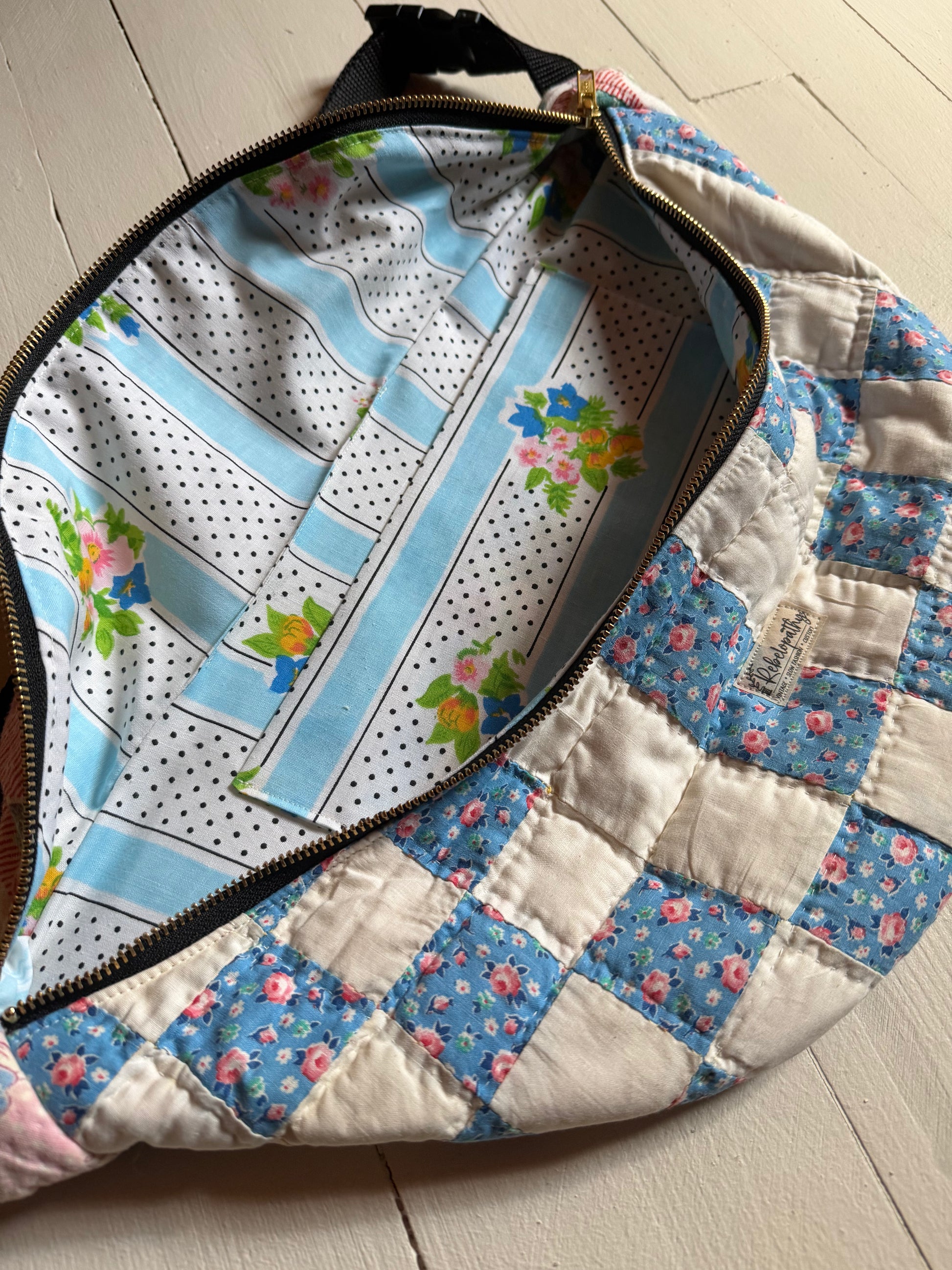 Quilted bag with floral and polka dot patterns on a wooden surface